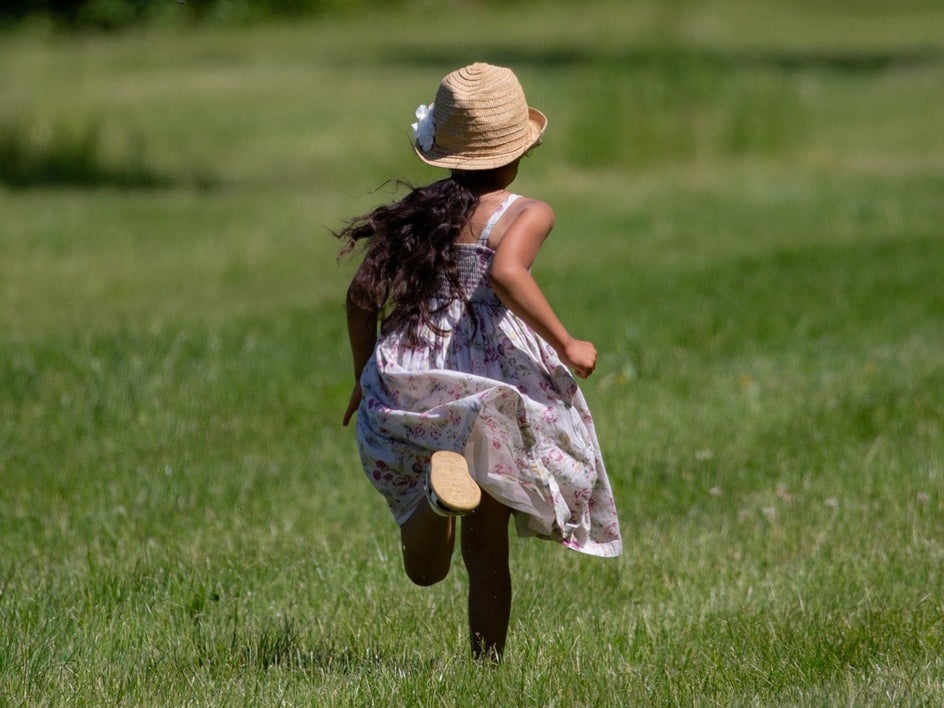 little girl running through field