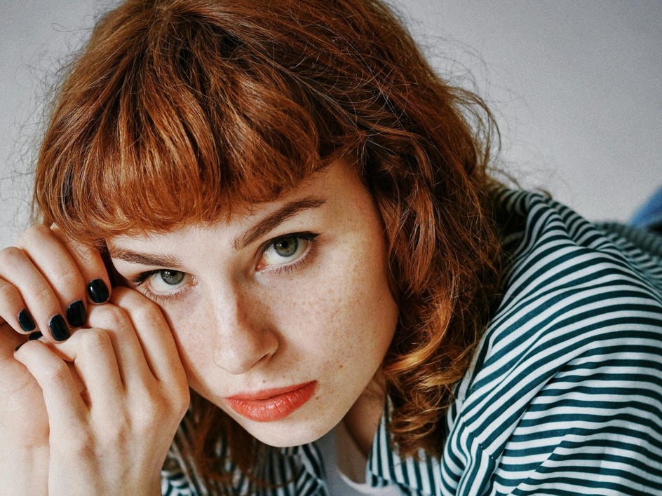 Woman with red hair and painted black nails