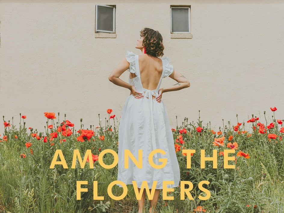 woman in white dress around flowers after wes anderson font and effect applied